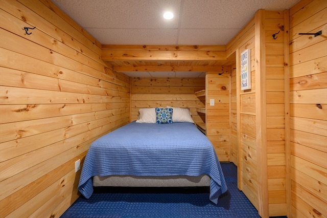 carpeted bedroom with wooden walls