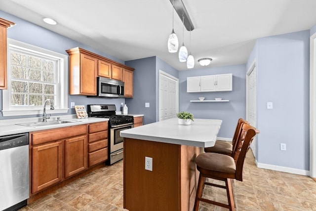 kitchen featuring sink, hanging light fixtures, stainless steel appliances, a center island, and a kitchen bar