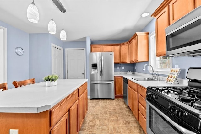 kitchen featuring a kitchen island, pendant lighting, sink, a kitchen bar, and stainless steel appliances