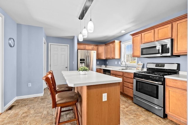 kitchen featuring decorative light fixtures, sink, a kitchen bar, a center island, and stainless steel appliances