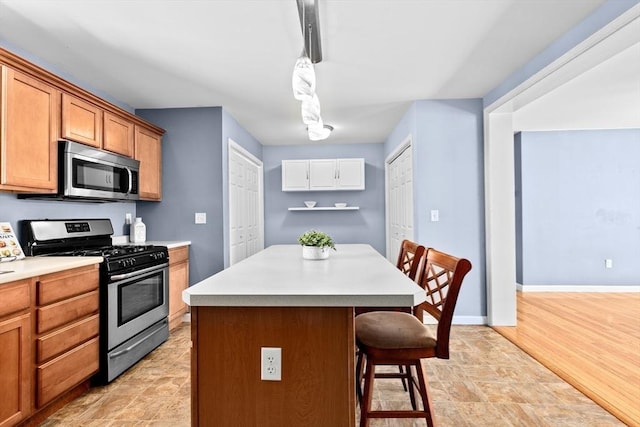 kitchen featuring hanging light fixtures, a breakfast bar area, a center island, and appliances with stainless steel finishes