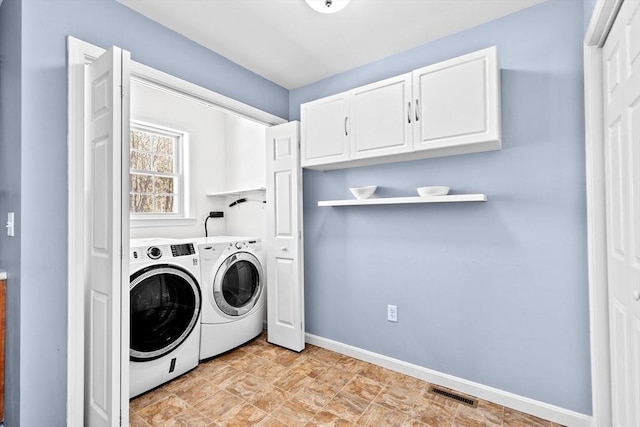 washroom featuring cabinets and washing machine and clothes dryer