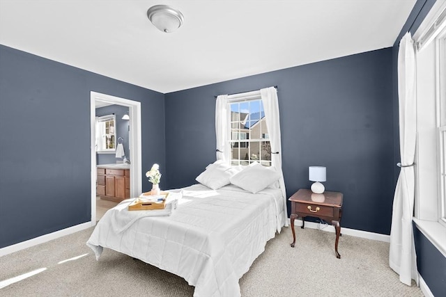 bedroom with connected bathroom and light colored carpet