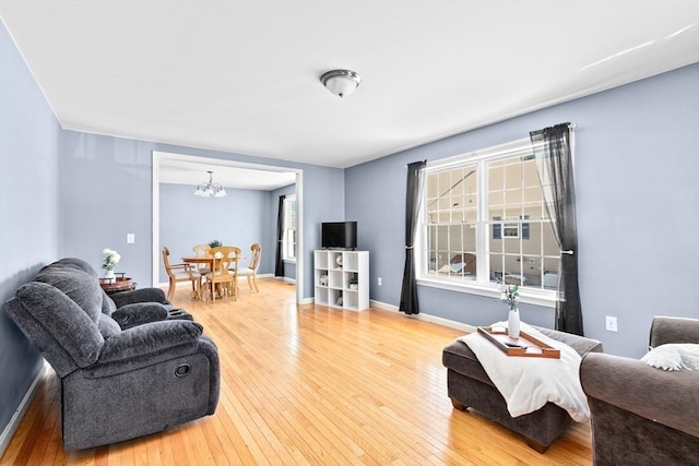 living room featuring wood-type flooring and an inviting chandelier