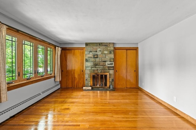 16 Sheldon Ave, Easthampton, MA 01027 - unfurnished living room featuring a baseboard heating unit, light wood-style flooring, and a fireplace
