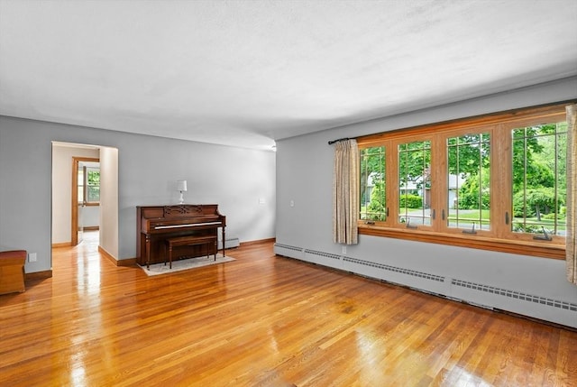 16 Sheldon Ave, Easthampton, MA 01027 - unfurnished living room featuring a baseboard heating unit, light wood-style floors, and baseboard heating