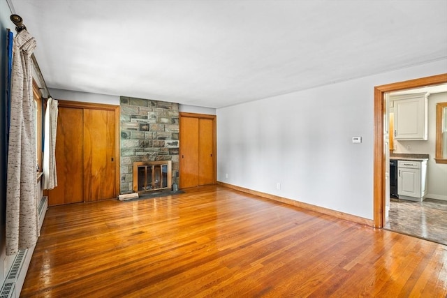 16 Sheldon Ave, Easthampton, MA 01027 - unfurnished living room featuring baseboard heating, wood finished floors, and a fireplace