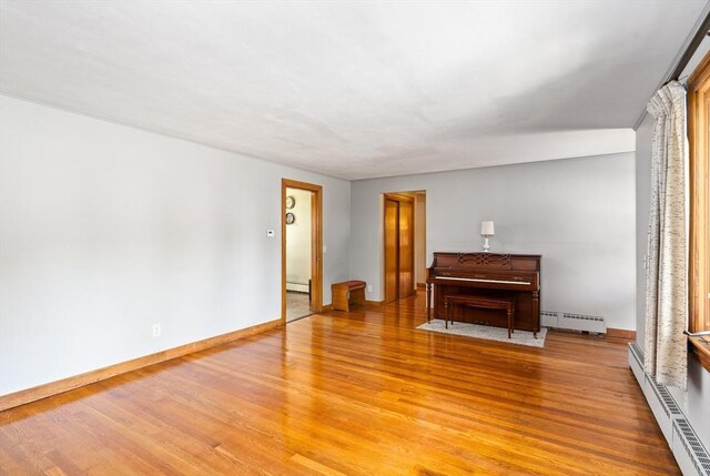 16 Sheldon Ave, Easthampton, MA 01027 - unfurnished living room with a baseboard heating unit, a baseboard radiator, and light wood finished floors