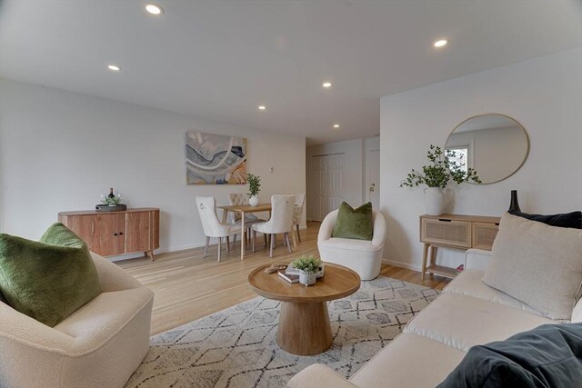 living area with recessed lighting, light wood finished floors, and baseboards