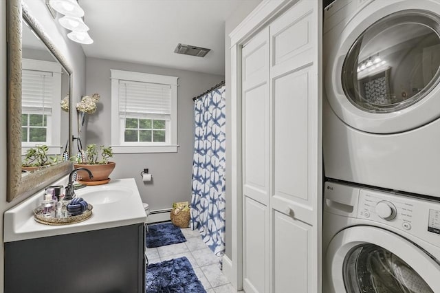 6 Lous Dr, Dudley, MA 01571 - full bath with estacked washer and dryer, vanity, a baseboard heating unit, tile patterned flooring, and a shower with curtain
