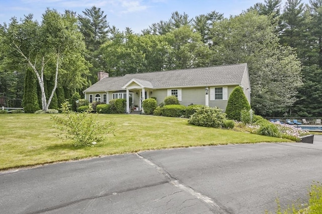 6 Lous Dr, Dudley, MA 01571 - view of front of property featuring a chimney, a front lawn, and view of wooded area
