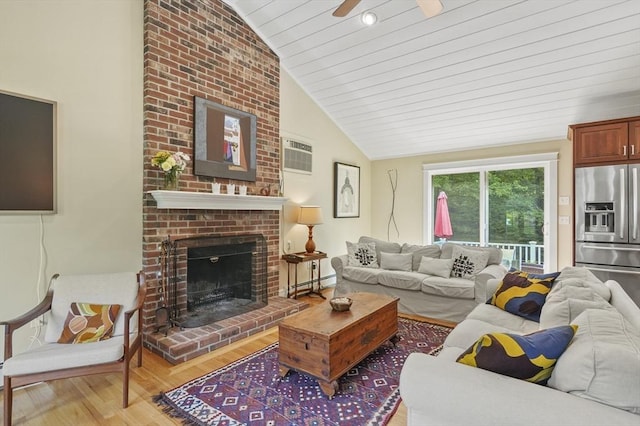 6 Lous Dr, Dudley, MA 01571 - living area featuring lofted ceiling, a baseboard radiator, wood finished floors, a brick fireplace, and an AC wall unit