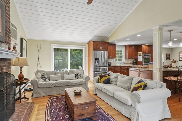 6 Lous Dr, Dudley, MA 01571 - living room with light wood-style flooring, vaulted ceiling, and a fireplace