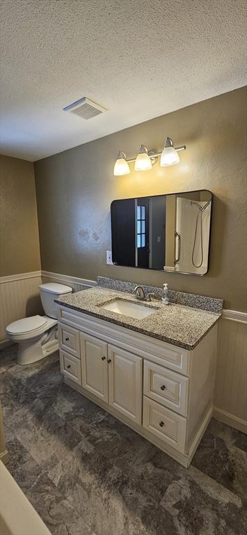 1 Wysocki Dr Unit 9, Dudley, MA 01571 - bathroom featuring a textured ceiling, vanity, wainscoting, and toilet