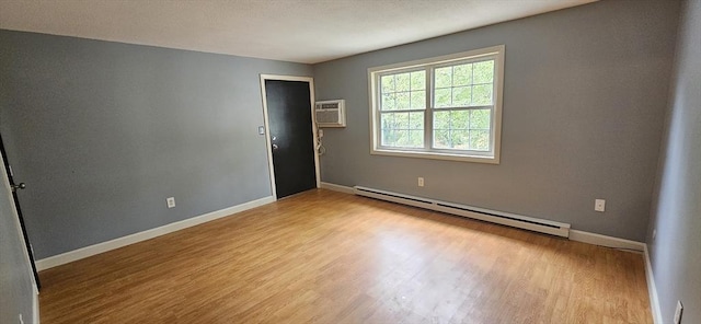 1 Wysocki Dr Unit 9, Dudley, MA 01571 - empty room featuring a baseboard radiator, wood finished floors, baseboards, and a wall mounted AC