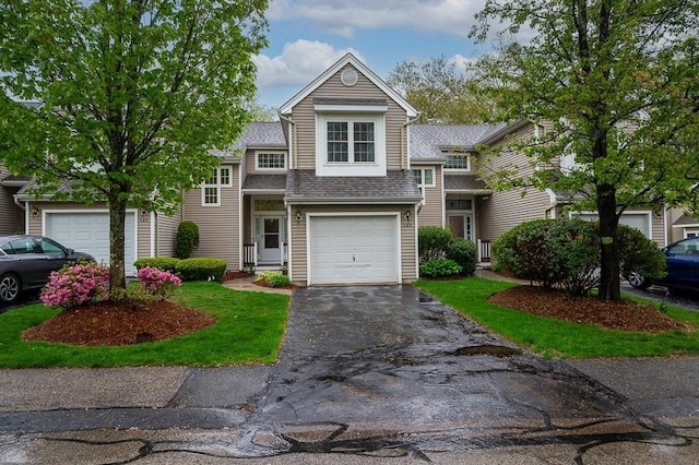 view of front of property featuring driveway and roof with shingles