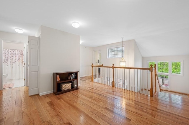 bonus room featuring light wood-type flooring and baseboards