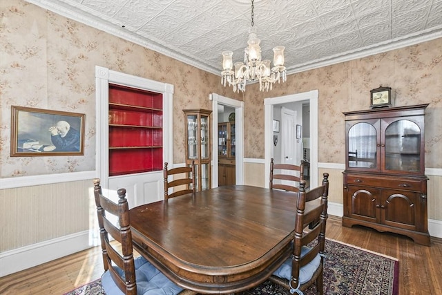 dining room featuring dark hardwood / wood-style flooring, a chandelier, and ornamental molding