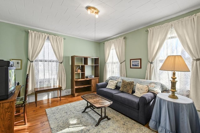 living room featuring wood-type flooring and ornamental molding