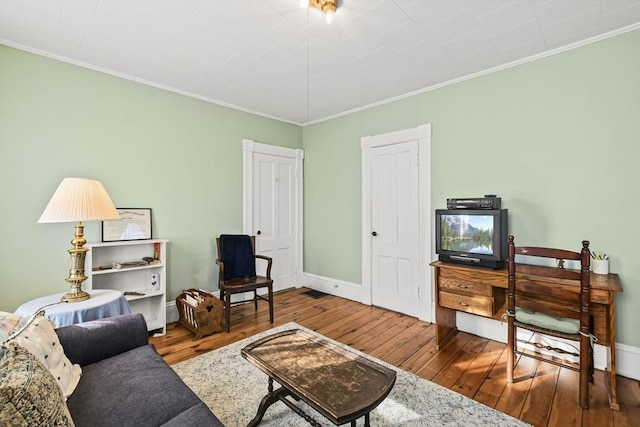 living room with hardwood / wood-style flooring and ornamental molding