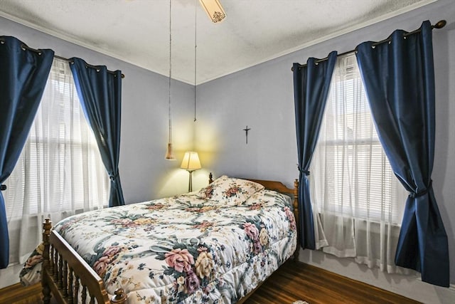 bedroom with multiple windows, ceiling fan, dark hardwood / wood-style flooring, and a textured ceiling