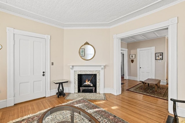 living room with ornamental molding, a textured ceiling, and hardwood / wood-style flooring