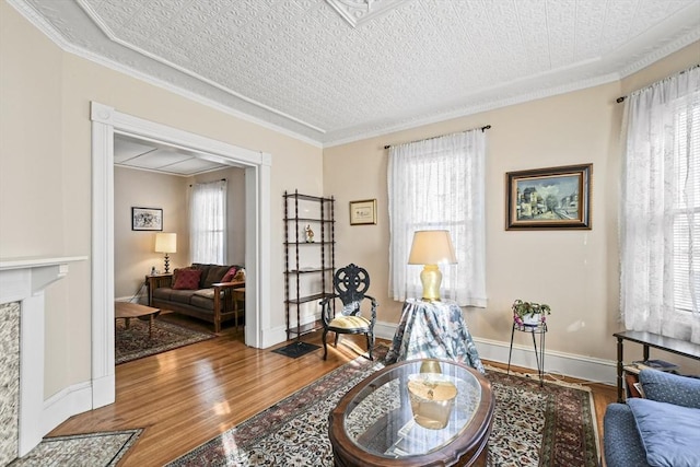 living area featuring hardwood / wood-style floors, a textured ceiling, and crown molding