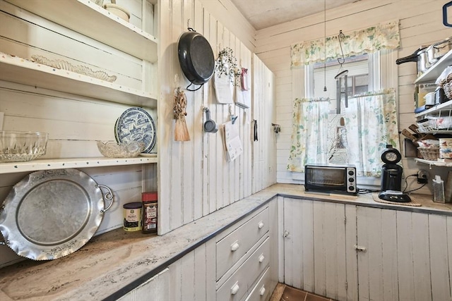 kitchen featuring wood walls and light stone countertops