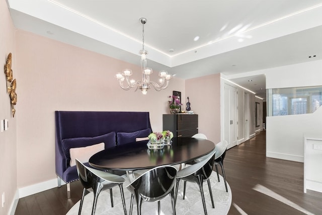 dining area featuring dark hardwood / wood-style floors and an inviting chandelier