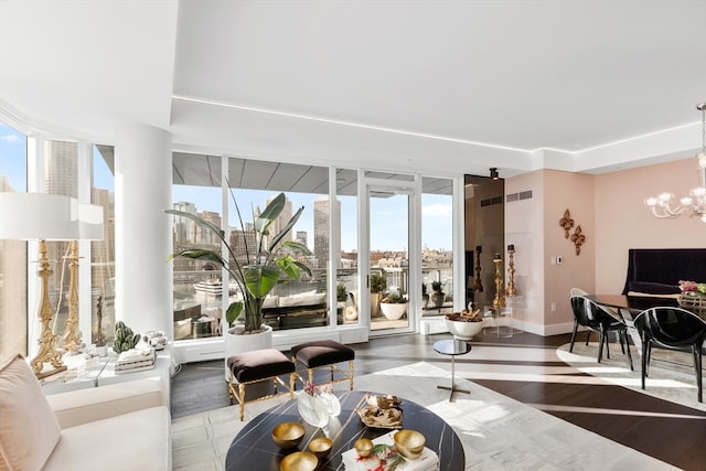 living room with an inviting chandelier, hardwood / wood-style flooring, and floor to ceiling windows