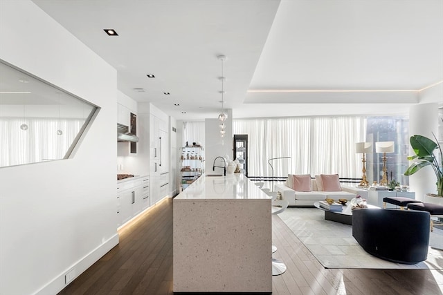 kitchen with white cabinets, hardwood / wood-style floors, sink, and decorative light fixtures