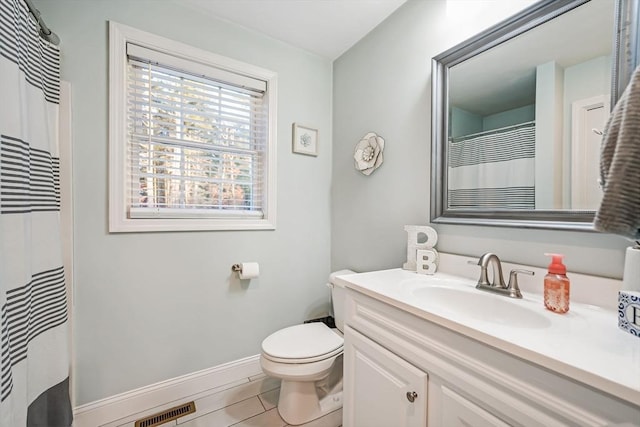 bathroom with toilet, vanity, and tile patterned flooring