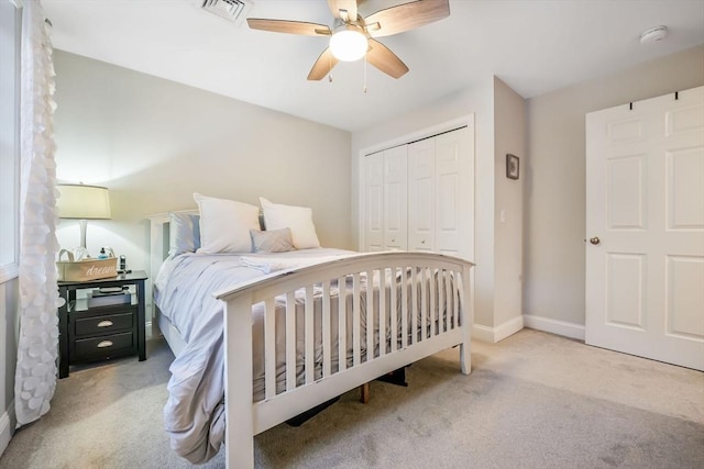 bedroom with light carpet, ceiling fan, and a closet