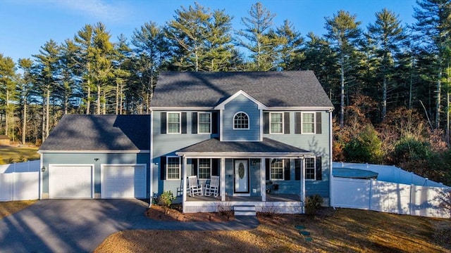 colonial home with a garage and a porch