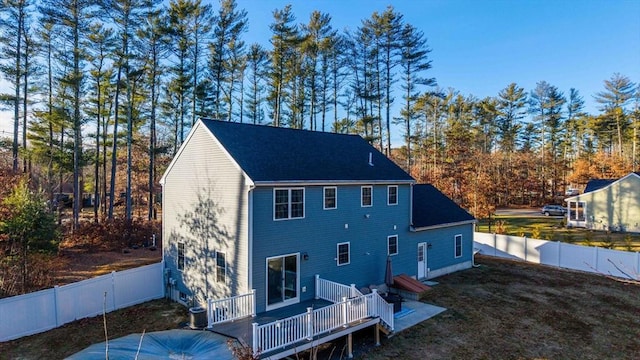 rear view of property featuring central AC unit and a wooden deck