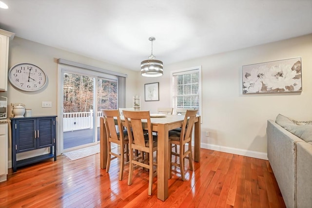 dining space with light hardwood / wood-style flooring and a chandelier