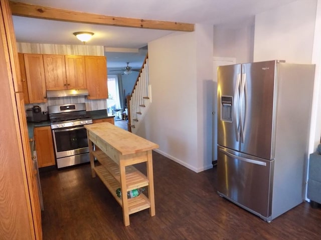 kitchen featuring appliances with stainless steel finishes, under cabinet range hood, dark wood-type flooring, ceiling fan, and beam ceiling