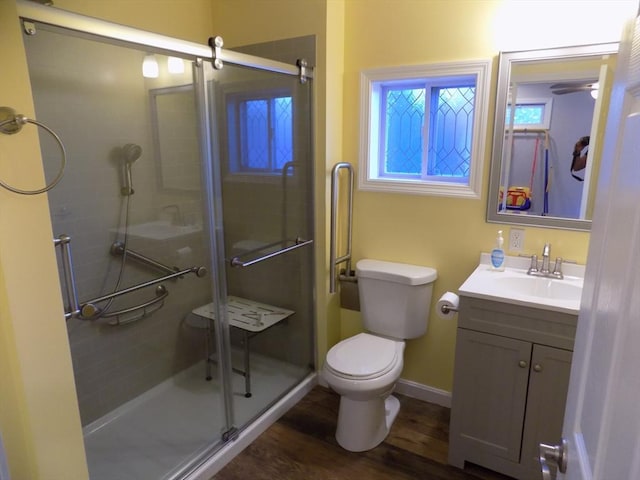 full bathroom featuring a shower stall, toilet, vanity, wood finished floors, and baseboards