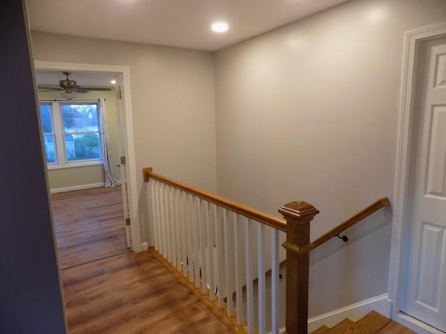 stairs featuring wood finished floors, recessed lighting, a ceiling fan, and baseboards