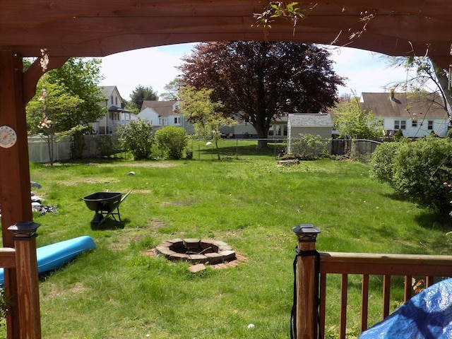 view of yard featuring an outdoor fire pit and a residential view