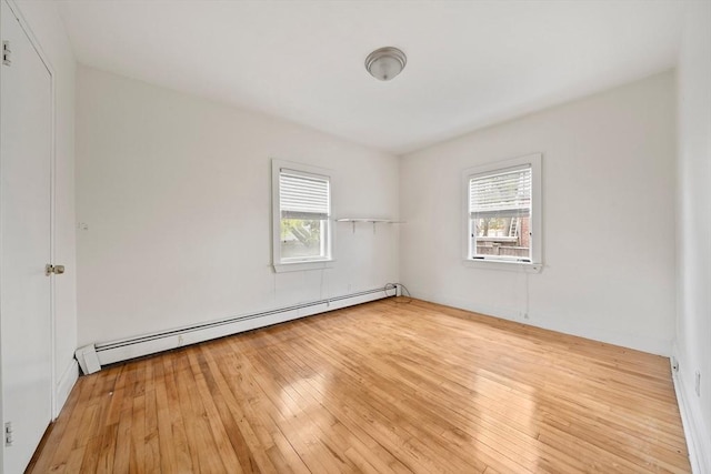 empty room with light wood-style flooring and a baseboard radiator