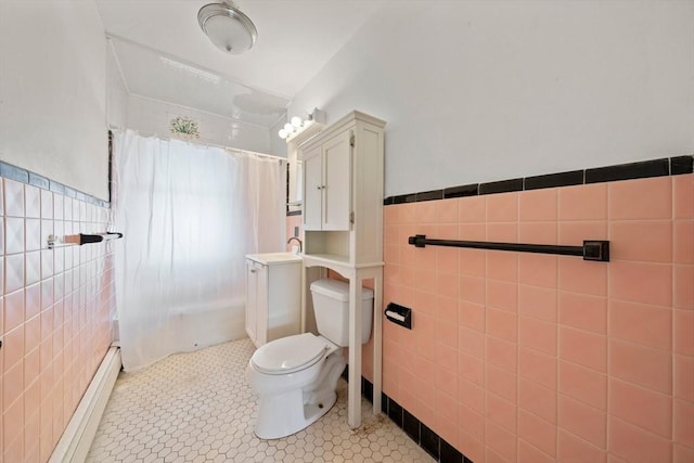 full bathroom featuring toilet, a shower with curtain, tile patterned floors, tile walls, and wainscoting