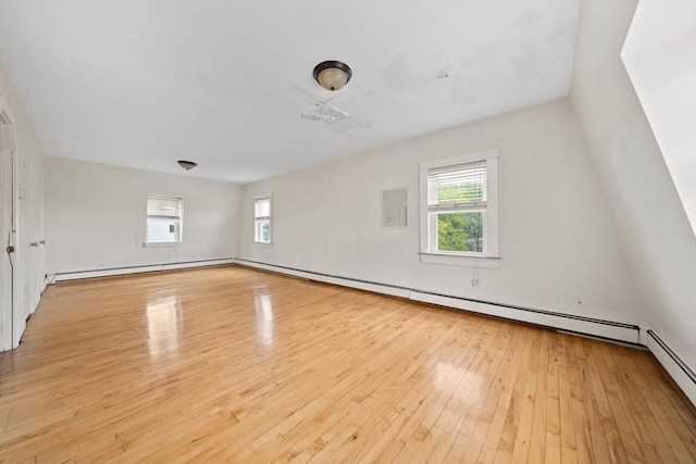 interior space featuring a baseboard heating unit, a healthy amount of sunlight, and wood-type flooring