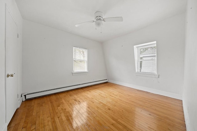 unfurnished room with baseboards, hardwood / wood-style floors, baseboard heating, and ceiling fan