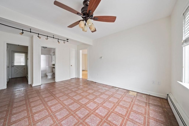 unfurnished bedroom with track lighting, light floors, ensuite bathroom, baseboards, and baseboard heating