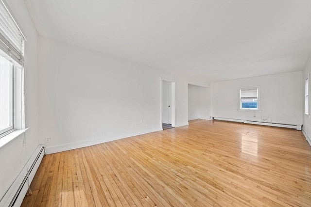 interior space with baseboards, a baseboard radiator, and light wood-type flooring