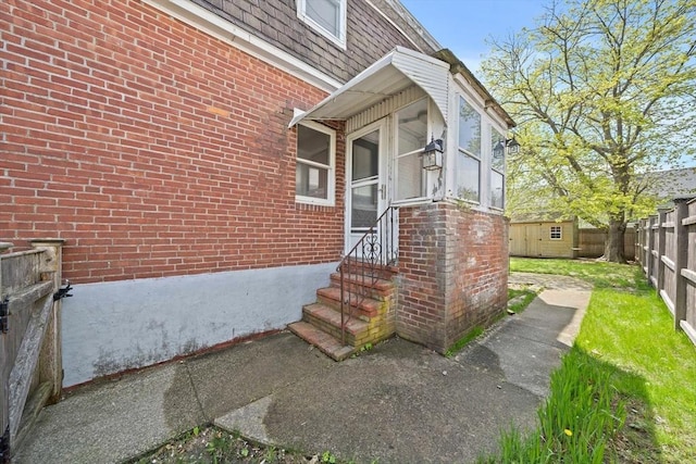 entrance to property with brick siding and fence