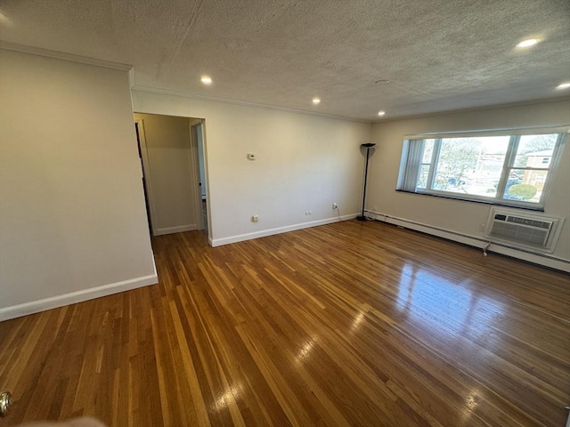 spare room featuring dark wood-type flooring, a wall mounted air conditioner, crown molding, and a textured ceiling