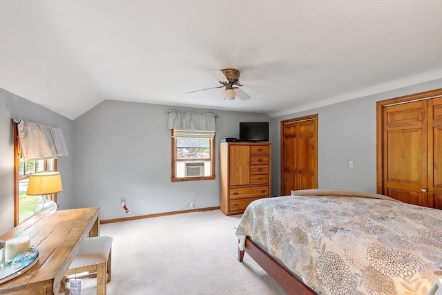 bedroom featuring light colored carpet, cooling unit, lofted ceiling, two closets, and ceiling fan