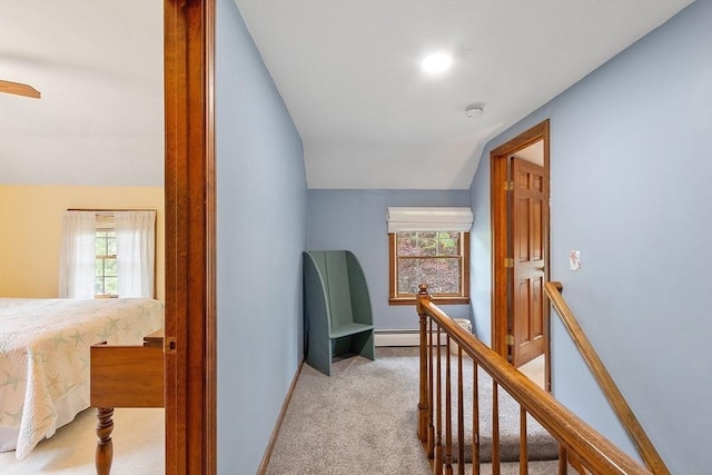 corridor with an upstairs landing, light carpet, vaulted ceiling, and baseboards